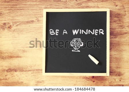 be a winner concept written on blackboard and cup sketch