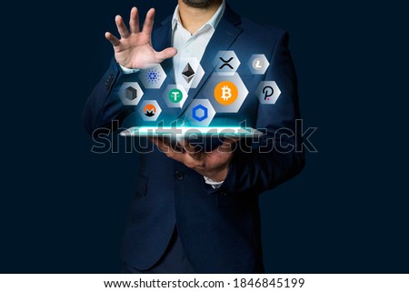 Cryptocurrency altcoin, Business man holding tablet showing growing virtual hologram of altcoin crypto and bitcoin, xrp, chainlink Royalty-Free Stock Photo #1846845199