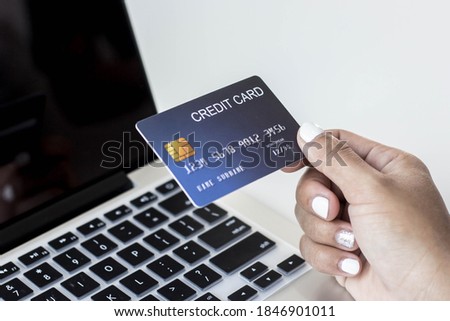 Hand holding credit card spending online payment using laptop in online shopping.