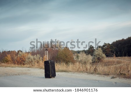 a lonely suitcase on a deserted road, a ban on travel and flights in quarantine