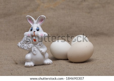 Easter holiday. Bunny and Easter eggs on the background of burlap. Photo.
