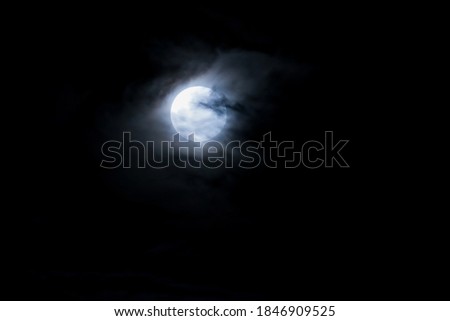 Blue moon on a dark cloudy sky.