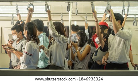 Many people on the train wear anti-virus masks and travel during rush hours. business asian man on sky train. Royalty-Free Stock Photo #1846933324