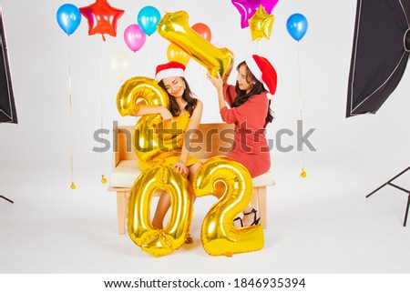 The joy of the Asian female model couple shoots a commercial for the concept of Happy New Year and Christmas in a fun studio : Welcome new year 2021
