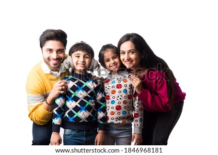 Asian Indian young family wears sweater or warm woolen or woollen winter cloths, standing isolated against white background