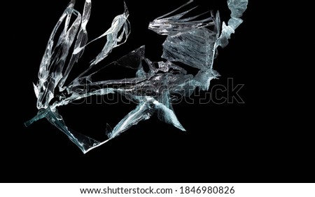 broken mirror and glass from impact on a black background in cracks in the form of an isolated abstraction