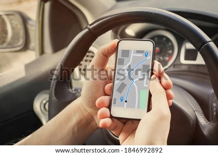 driver using direction navigation on GPS map on the screen of mobile smartphone in the car Royalty-Free Stock Photo #1846992892