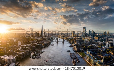 Wide panoramic view to the modern skyline of London, United Kingdom, along the Thames river during sunset time