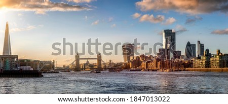 Panoramic view to the modern skyline of London, United Kingdom, with Thames River, Tower Bridge and the City during sunset time