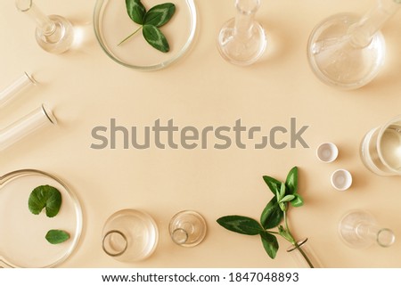 Laboratory glassware with serum and oil on beige background. Natural medicine, cosmetic research, bio science, organic skin care products. Flat lay, top view, copy space. Royalty-Free Stock Photo #1847048893
