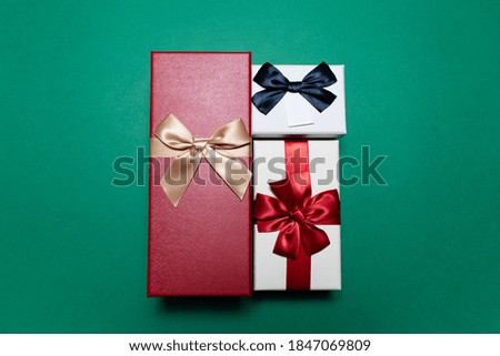 Close-up of three gift boxes on green background.