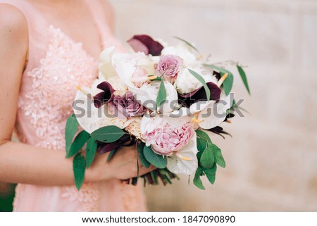 the bride holds a bouquet of roses, calla lilies, peonies and eucalyptus branches