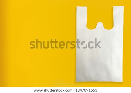 White Color Non Woven Fabric shopping bag with yellow background. Copy space for text and logo. Sale banner concept. 