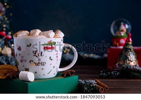 Christmas cup of cocoa with marshmallow and spices and retro toys with Christmas tree branches on background. Festive New Year card.