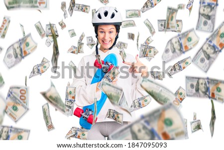 Beautiful brunette young woman wearing safety helmet and skate smiling happy pointing with hand and finger