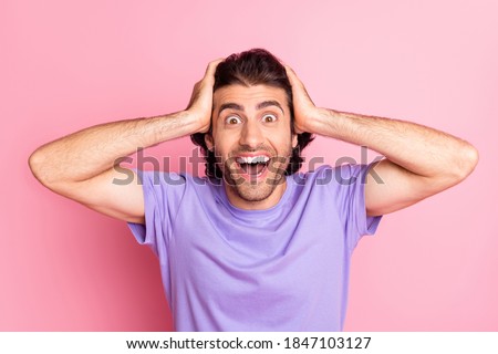 Photo of funny amazed guy hands head open mouth wear violet t-shirt isolated pastel pink color background