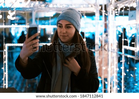 Young woman taking selfie at christmas market