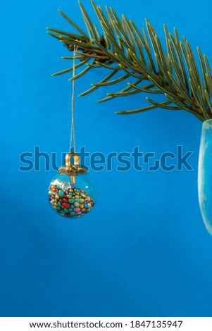 Beautiful Christmas tree toy in the form of a glass ball with colorful elements inside and branch of a tree, Christmas tree.