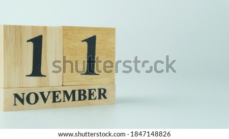 Wooden letters write the word November and the numbers 11 on white background with copy space. 11.11 single day sale concept
