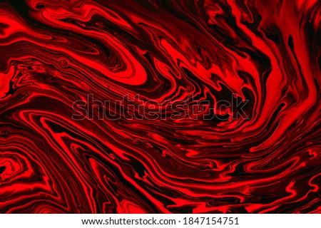 Fluid art texture. Abstract background with swirling paint effect. Liquid acrylic artwork with colorful mixed paints. Can be used for background or poster. Red, black and orange overflowing colors.