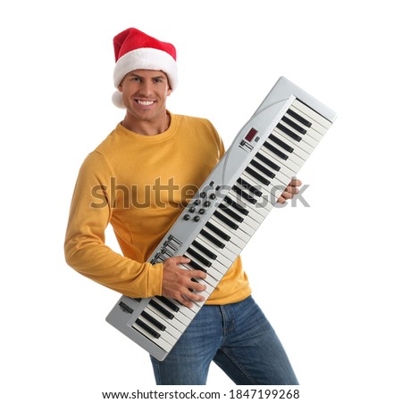 Man in Santa hat playing synthesizer on white background. Christmas music
