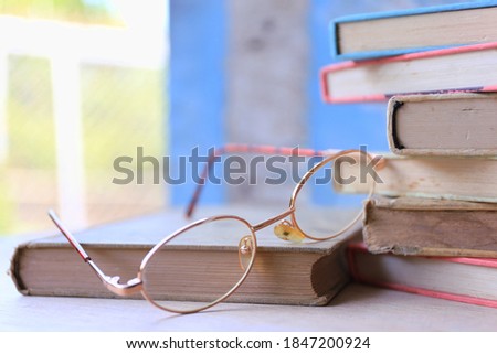 Close-up of old glasses on a pile of old books selective focus and shallow depth of field