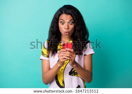 Photo of charming surprised young lady hold telephone funny face wear banana print t-shirt isolated turquoise color background