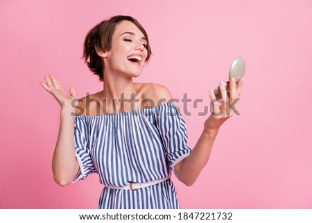 Photo portrait of pretty girl looking at mirror smiling laughing wearing casual striped outfit isolated on pastel pink color background