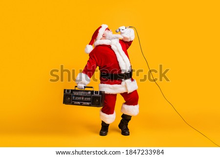 Full size photo of fat crazy grey white hair bearded santa claus sing x-mas christmas song hold boom box wear headwear cap isolated over bright shine color background