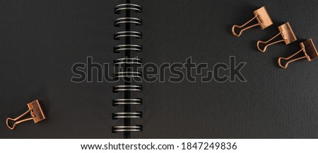 black colored pages of an open album on a metal spiral and golden pushpins. Business concept. Web banner. Background for text.