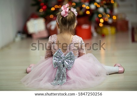 child from the back under the christmas tree