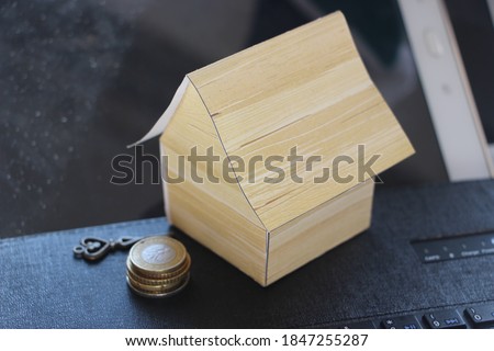 House model, laptop and money coins on laptop keyboard. Mortgage concept, real estate business concept.