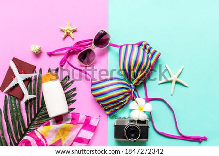 Summer items and accessories  traveler woman colorful bikini, camera, passport and airplane go to travel plan holiday vacation in the beach. Tropical sea. Unusual top view, Travel and Summertime 
