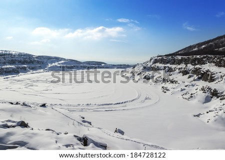 Stones covered with snow on a frozen lake view Royalty-Free Stock Photo #184728122