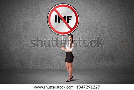Young business person holdig traffic sign with IMF abbreviation, technology solution concept