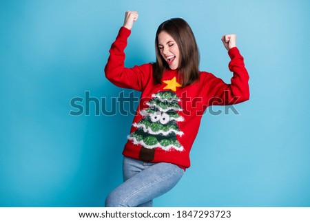 Photo of ecstatic crazy girl in christmas tree sweater raise fists scream win x-mas tradition lottery isolated over blue pastel color background