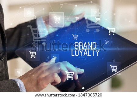 Young person makes a purchase through online shopping application with BRAND LOYALTY inscription