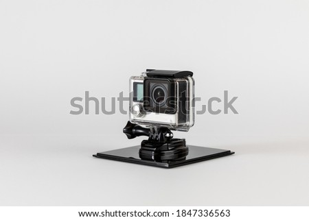 Action camera in waterproof housing and on stand to keep it stationary