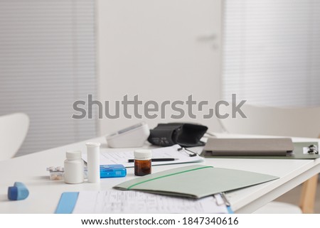 Image of workplace of doctor with medical card medicines and other supplies on it at hospital
