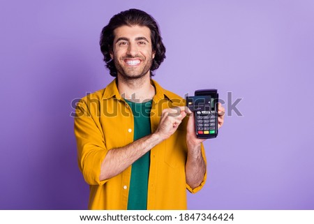 Photo portrait of excited man paying with card using terminal isolated on vivid violet colored background