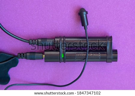 The lavalier microphone is connected to the power module. Purple background