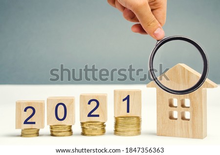 2021 wooden blocks and miniature house. Real estate concept. Family budget planning. Investments, plans, savings. Mortgage and mortgage rates. Forecasts. Loan. Refinance home Royalty-Free Stock Photo #1847356363
