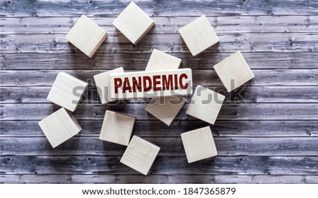 Pandemic, text is written on wooden blocks and gray table surface