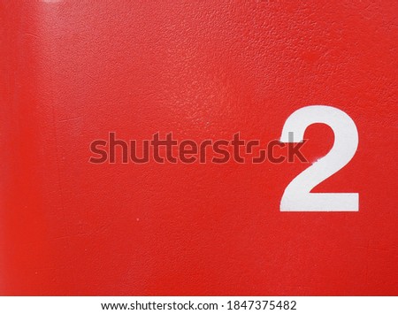 White number two on a red cement wall.