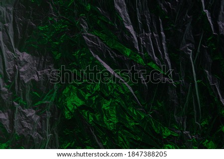 abstract green-black texture of crumpled plastic film for Wallpaper and backgrounds
