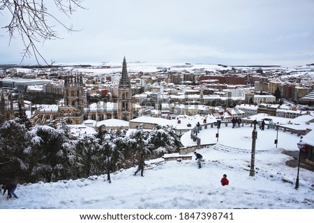Cathedral of Burgos snowy view from the castle with people playing