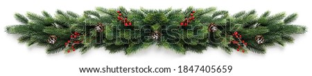 Christmas border frame of tree branches with red berries and pine cones