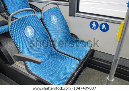 Blue fabric seats in the bus for elderly, people with disabilities and passengers with children. Special seats in public transport for certain categories of passengers.