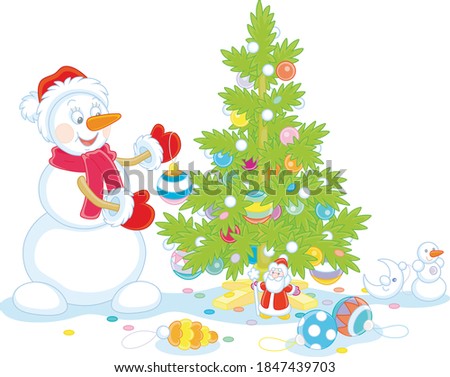 Friendly smiling snowman with a red hat, a warm scarf and mittens decorating a prickly green Christmas tree with colorful balls, garlands and toys, vector cartoon illustration