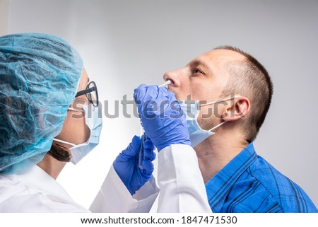Coronavirus test - Medical worker taking a swab for corona virus sample from potentially infected man. covid-19 nasal swab test - doctor taking a mucus sample from patient nose in hospital